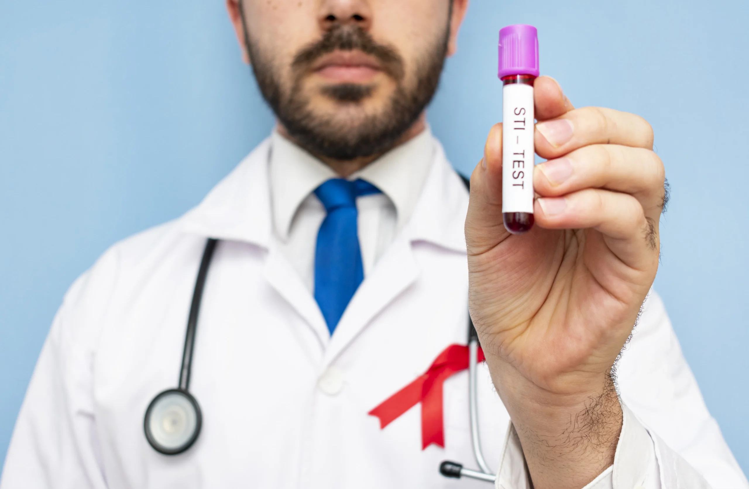 A doctor with a red awareness ribbon holding a blood vial, representing services from an online clinic for HIV prevention.