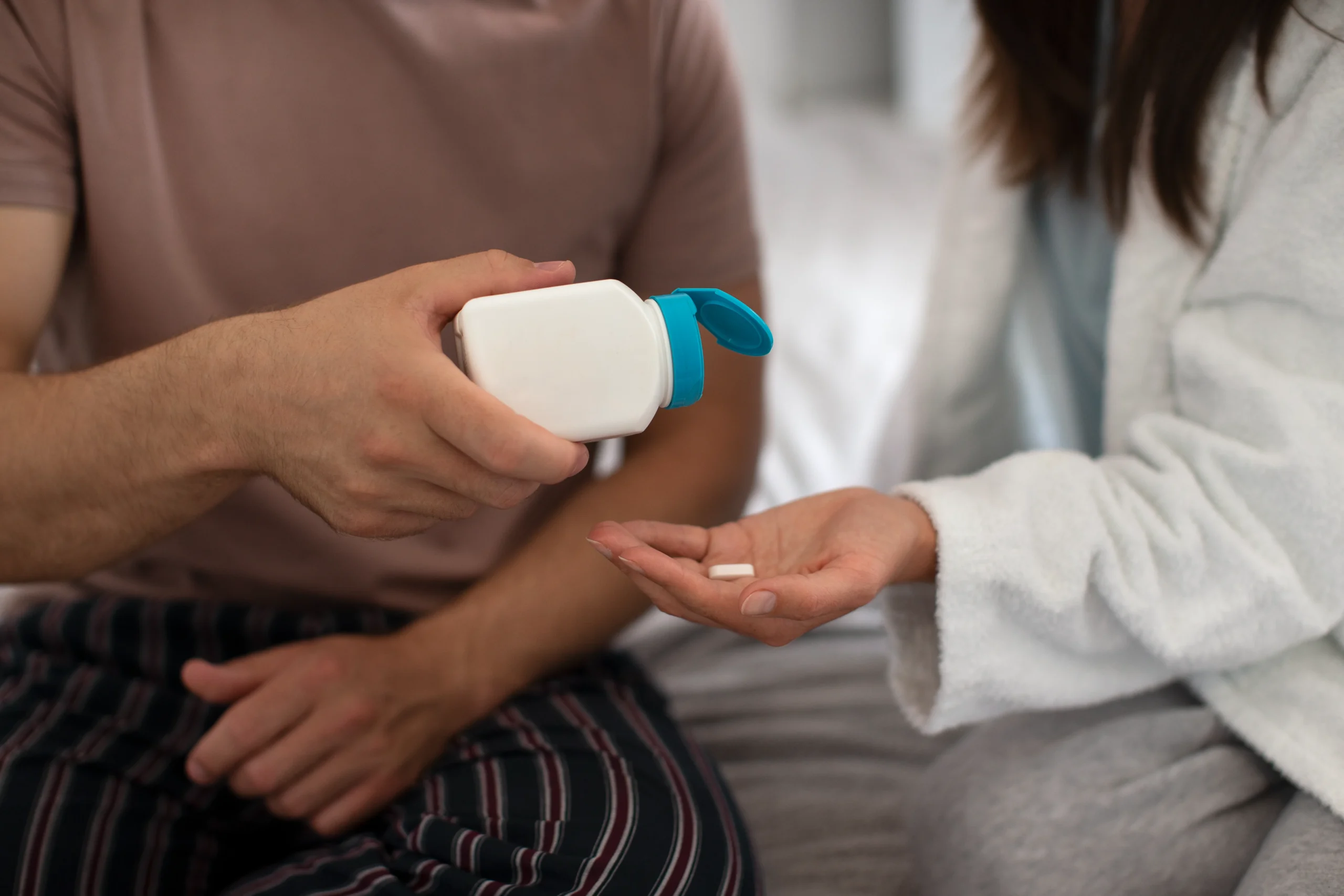 A person dispensing a daily PrEP pill into a palm for consistent HIV protection.