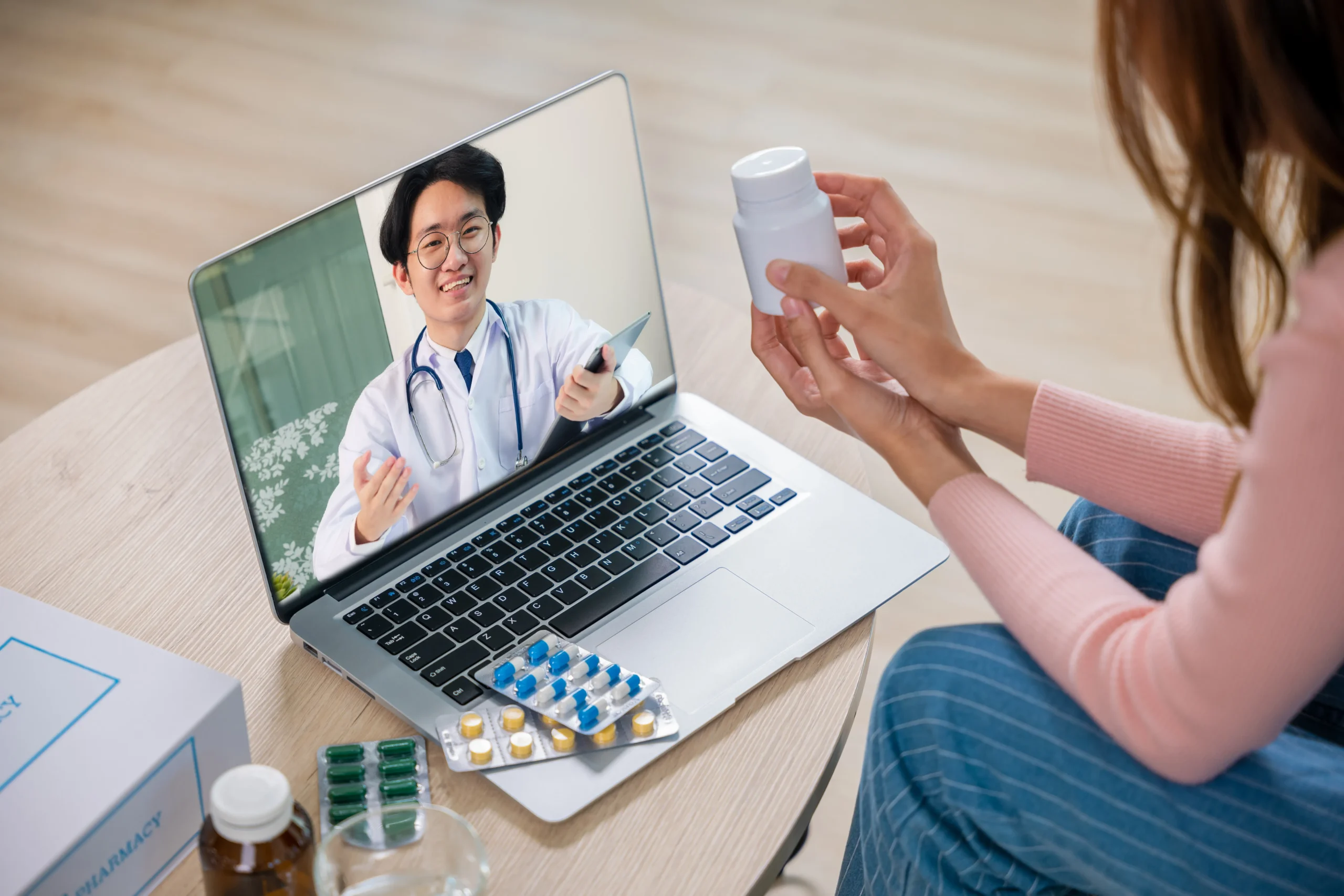 Patient holding a pill bottle while having a video consultation with a doctor for telehealth PrEP.