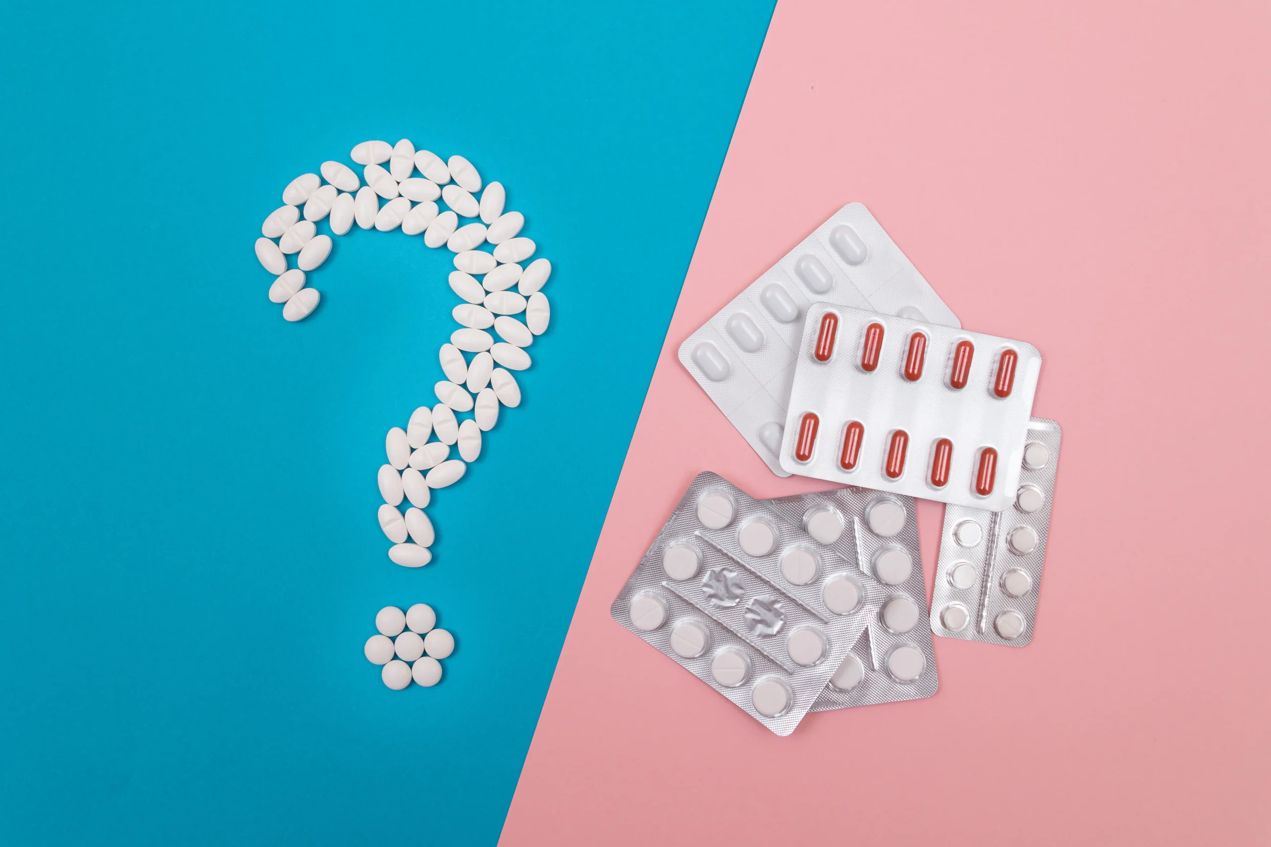A question mark made of white pills next to blister packs of medication, symbolizing the process of debunking common PrEP myths.
