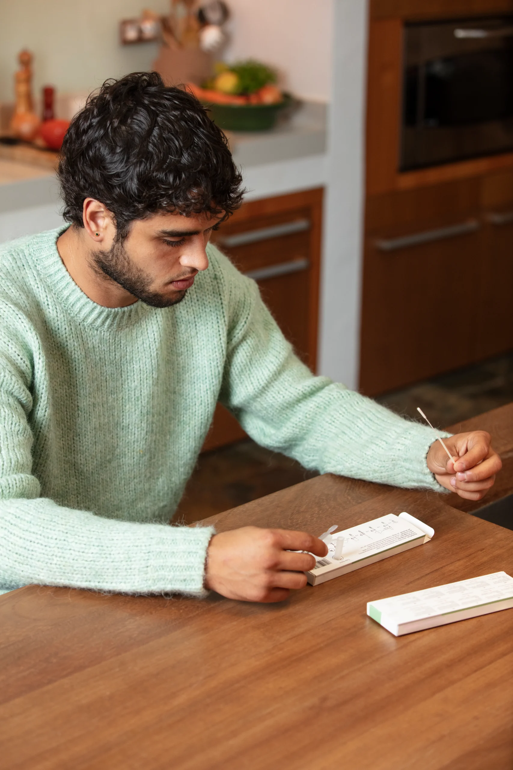 A young man unboxing an easy-to-use STI testing kit with telehealth options at his counter.