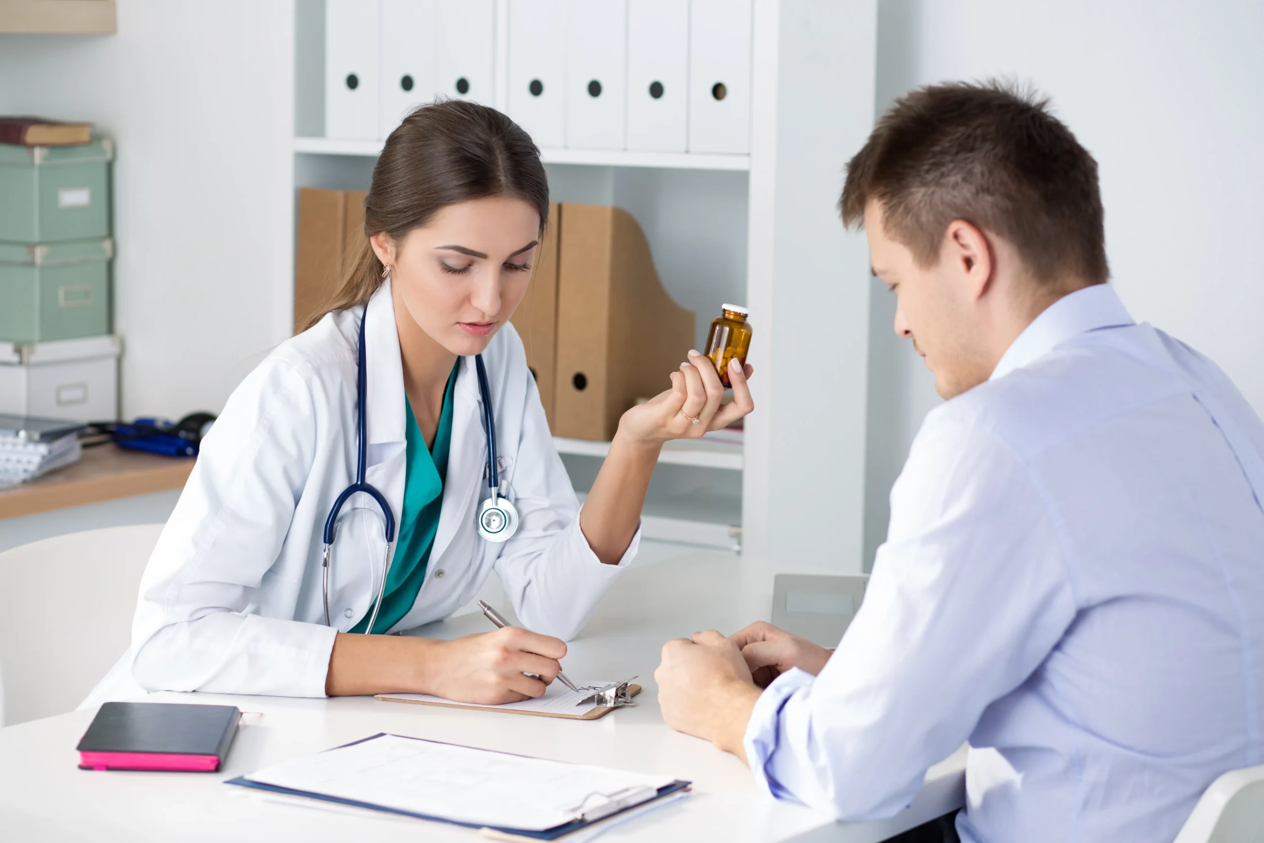 Doctor writing a prescription while showing a medicine bottle containing STI prevention medication.