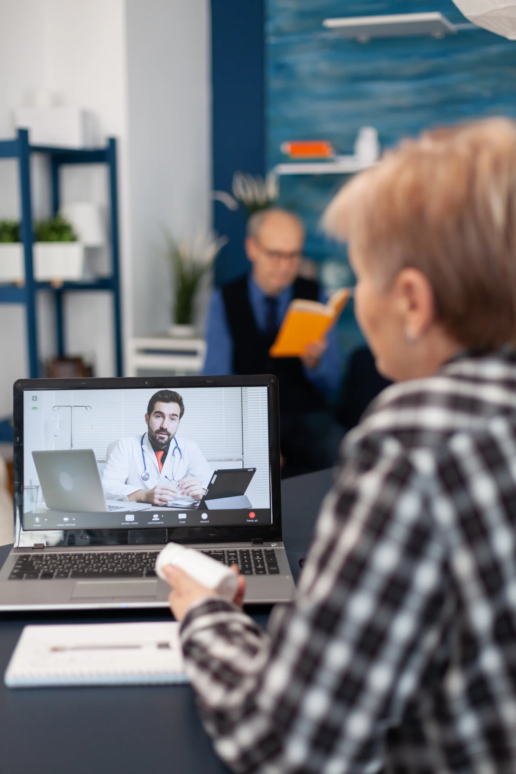 Patient holding prescription medication during a virtual consultation for PrEP home delivery.