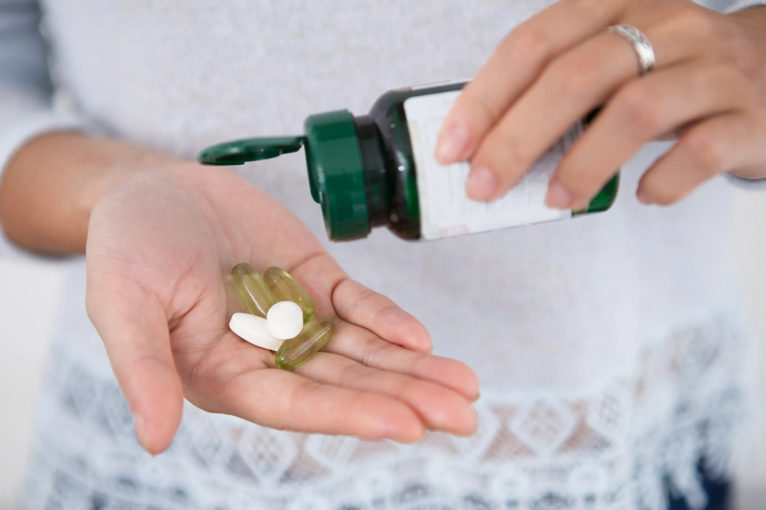 Person holding tablets and capsules used in Doxy-PEP regimens for post-exposure STI prevention.