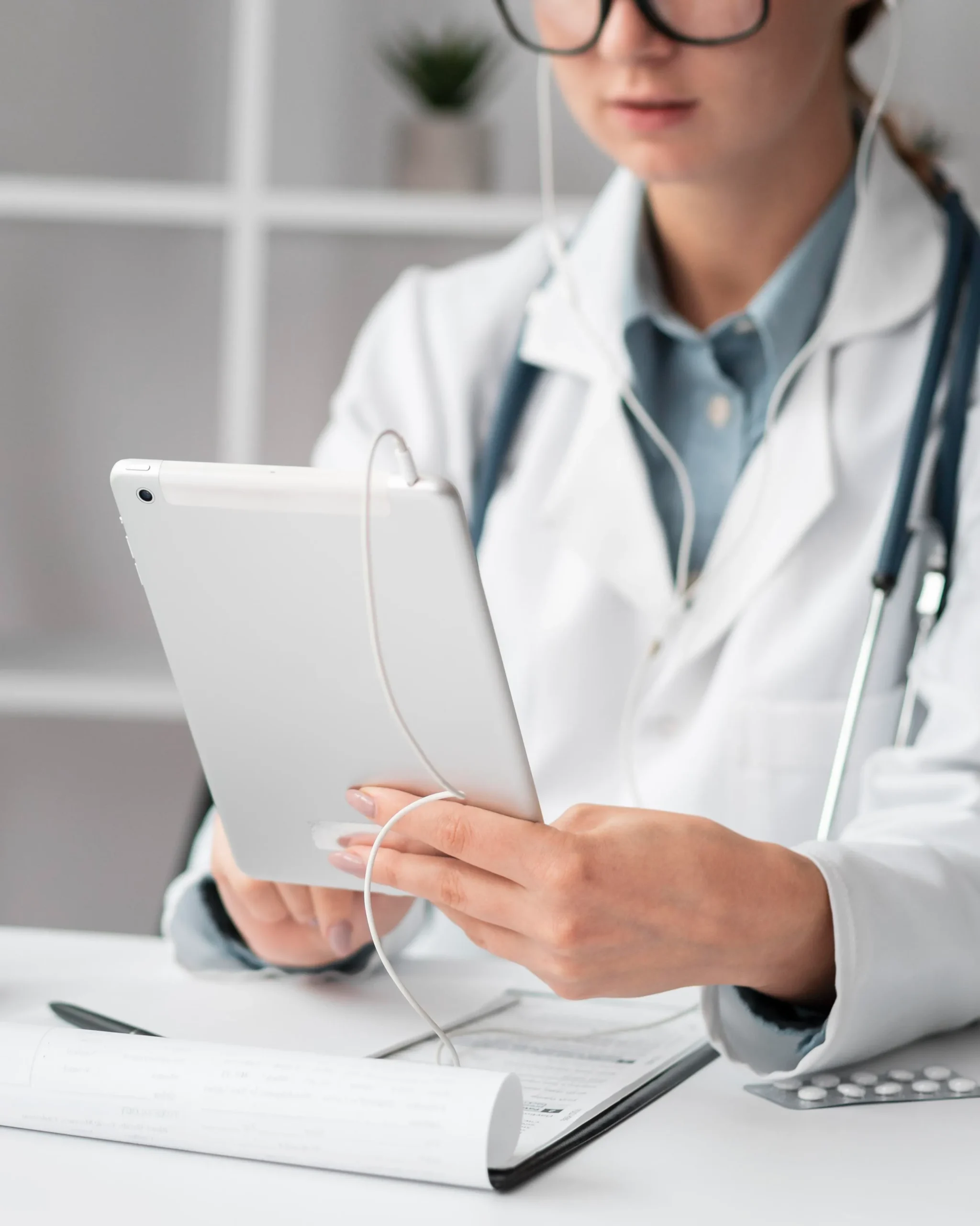 Doctor reviewing patient files on a tablet to approve an online PrEP prescription.